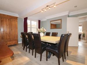 a dining room with a wooden table and black chairs at Hambleton House Castle Donington in Castle Donington +18 photos