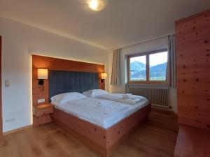 a bedroom with a large bed and a window at Hochtenn Lodge in Zell am See - Steinbock Lodges in Zell am See