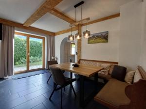a dining room with a table and a couch at Hochtenn Lodge in Zell am See - Steinbock Lodges in Zell am See
