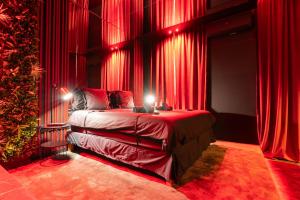 a bedroom with red curtains and a bed with a christmas tree at Évasion intime : Love Room de luxe à Cannes in Cannes