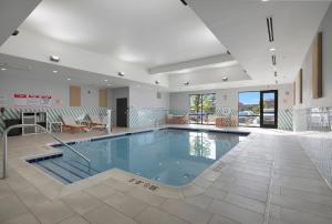 a large swimming pool in a building with a pool at Holiday Inn - Chicago - Tinley Park by IHG in Tinley Park
