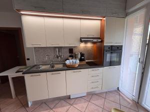 a kitchen with white cabinets and a sink at ITM Lakeside Apartment Lecco in Lecco +6 photos