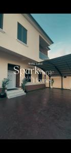 a building with a sign on the side of it at Spark Merge Luxury Homes in Mama
