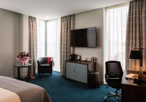 a hotel room with a bed and a flat screen tv at Mercure Bridgwater in Bridgwater
