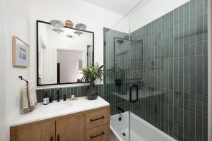 ein Badezimmer mit Waschbecken und Dusche mit Spiegel in der Unterkunft Newport Coast Bungalow in Newport Beach + 15 Fotos