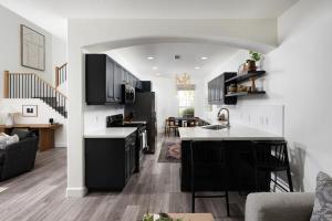 eine Küche mit schwarzen Schränken und ein Wohnzimmer in der Unterkunft Newport Coast Bungalow in Newport Beach