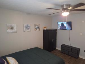 a bedroom with a bed and a flat screen tv on the wall at Yellow Mellow in Jackson