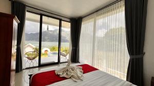 a bedroom with a bed and a large window with a view at lake hill view in Kintamani