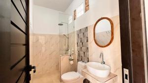 a bathroom with a sink and a toilet and a mirror at lake hill view in Kintamani