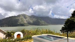 a swimming pool next to a body of water at lake hill view in Kintamani