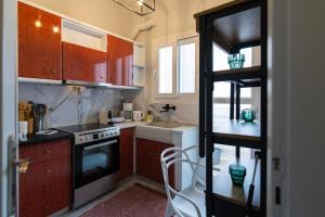 a kitchen with red cabinets and a stove at Noir Luxury 1 bedroom Atelier in Mesochórion