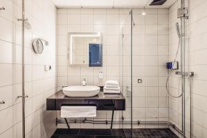 ein Badezimmer mit Waschbecken und Dusche in der Unterkunft Varbergs Kusthotell in Varberg + 68 Fotos