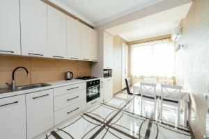 una cucina con armadi bianchi e pavimento in vetro di Apartment ultra center Sky House a Chişinău Altre 7 foto
