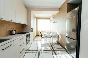una cucina con armadi bianchi e pavimento in vetro di Apartment ultra center Sky House a Chişinău