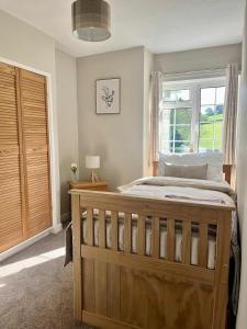 a bedroom with a large bed with a window at Ty Newydd in Llangyniew +26 photos