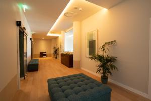 a living room with a couch and a plant at NAU Sao Rafael Suites - All Inclusive in Albufeira