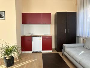 a kitchen with red cabinets and a white refrigerator at Hotel Neue Traube in Fellbach