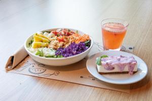 a salad and a bowl of food and a drink on a table at Hotel Acta Moa in Lisbon