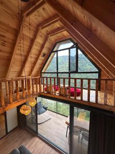 een zolderkamer met een groot raam in een hut bij Foresta Suit Bungalov in Ardeşen