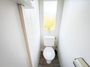 ein Badezimmer mit Toilette und Fenster in der Unterkunft Happy Camp Mobile Homes in Il Pioppeto Camping&Residence in Marina di Montenero + 11 Fotos