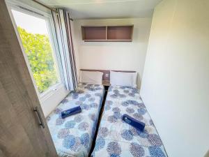 ein Bett in einem Zimmer mit Fenster in der Unterkunft Happy Camp Mobile Homes in Il Pioppeto Camping&Residence in Marina di Montenero