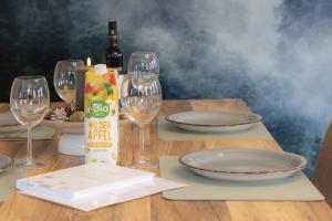 a wooden table with glasses and plates and wine bottles at 3 Zimmer Ferienwohnung Harter Brocken in Sankt Andreasberg
