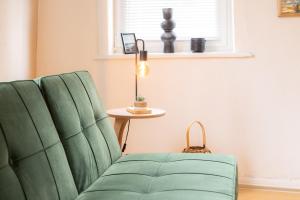 a green chair in a living room with a lamp at 3 Zimmer Ferienwohnung Harter Brocken in Sankt Andreasberg