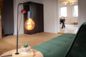 a lamp sitting on a table next to a couch at 3 Zimmer Ferienwohnung Harter Brocken in Sankt Andreasberg