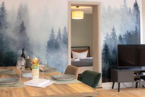 a dining room with a table and a wall with trees at 3 Zimmer Ferienwohnung Harter Brocken in Sankt Andreasberg +12 photos