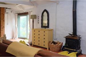 a living room with a couch and a wood stove at Cottage Sleeps 2- Parking Wood Fire Garden Pets in Lizard