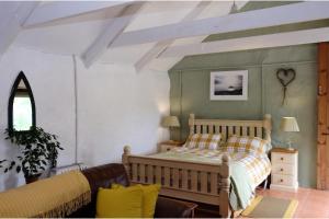 a bedroom with a bed and a couch at Cottage Sleeps 2- Parking Wood Fire Garden Pets in Lizard