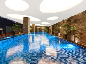 a swimming pool in a hotel with blue tiles at Melia Makassar in Makassar