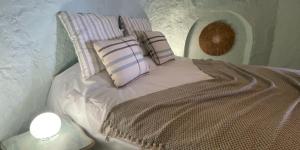 a bed with pillows on it in a room at Casa Cueva Solara, peace and nature in Cabo de Gata in Níjar +46 photos