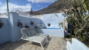 a patio with a chair and a swimming pool at Casa Cueva Solara, peace and nature in Cabo de Gata in Níjar