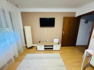 ein Wohnzimmer mit einem Flachbildfernseher an der Wand in der Unterkunft Alari Loft in Korbach