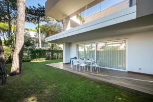 a dining area on the deck of a house at Summer Villas in Lignano Sabbiadoro +44 photos