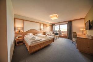 a hotel room with a bed and a balcony at Hotel Rosslaufhof in Castelrotto +100 photos