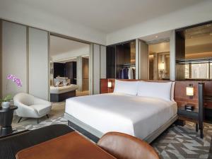 a bedroom with a large white bed and a chair at Fairmont Singapore in Singapore +103 photos