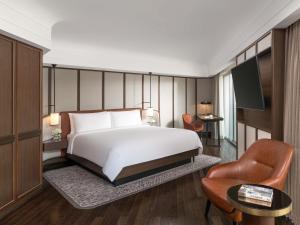 a hotel room with a bed and a chair at Fairmont Singapore in Singapore