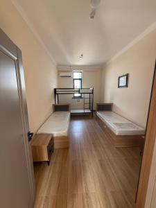 an empty room with two beds and a window at Hostel in Tashkent
