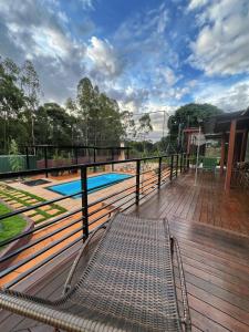 una terraza con banco y piscina en Casa Container, en Santa Rita do Passa Quatro