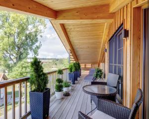 a porch with chairs and a table on a deck at Tegernsee Luxury Chalet in Erlach