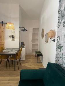 a dining room and living room with a table and chairs at Riverside Apartment in Makó