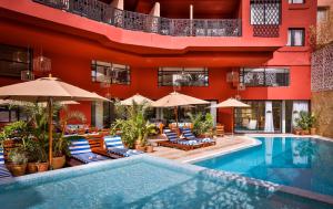 a hotel with a swimming pool with chairs and umbrellas at 2Ciels Boutique Hôtel in Marrakech
