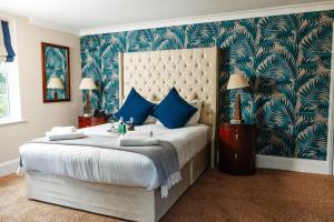 a bedroom with a large bed with blue and green wallpaper at Woodland Manor Hotel in Bedford +114 photos