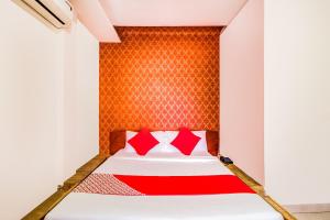 ein Schlafzimmer mit einem Bett mit roten Kissen in der Unterkunft Collection O Panchratna in Panvel