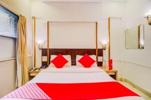 ein Schlafzimmer mit einem großen Bett mit roten Kissen in der Unterkunft Collection O Panchratna in Panvel + 37 Fotos