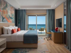 a hotel room with a bed and a television at Rixos Water World Aktau - Theme Park Free Access in Aktau