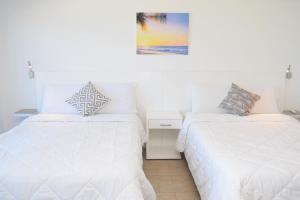 une chambre avec deux lits et un tableau au mur dans l'établissement Ocean front Villa Marlin, best location in hotel zone #109, à Cancún 50 autres photos