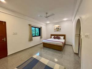 a bedroom with a bed and a window at Zuna Stayz Morjim in Morjim